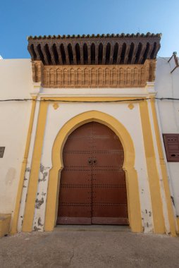 El Jadida, Fas - 16.11.2019: Tipik, eski, kahverengi, karmaşık şekilde oyulmuş, çivili, Fas riad kapısı, kapı çerçevesi ve eski ev. Portekiz 'in tahkim edilmiş Mazagan kenti UNESCO olarak kaydedildi.