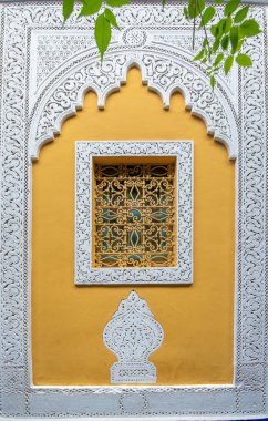 Tipik, eski, süslü, karmaşık yontulmuş, çivili, Fas tarzı pencere, çerçeve ve eski ev. Marakeş, Fas 'taki güzel boyalı evler manzaralı.