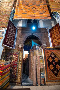FES, MOROCCO - 20 Kasım 2019: Medine 'nin merkezindeki bir çarşıda renkli Fas halıları ve berber halıları sergilenen halı dükkanının içi. Fes El Bali (Fez Labirenti)
