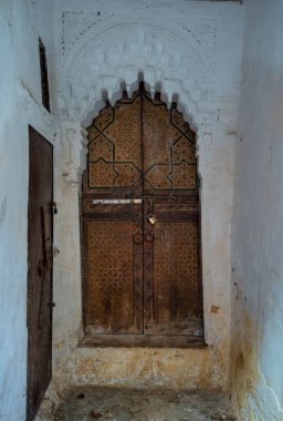 Geleneksel Fas tarzı bir antik ahşap giriş kapısı tasarımı. Marakeş ya da Fas 'ın eski Medine' sinde. Tipik, eski, karmaşık bir şekilde oyulmuş, çivili, Fas riad kapısı.