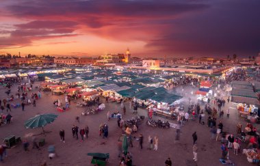 Marakeş, Fas - 22 Kasım 2019: İnsanlar gün batımında ünlü Meydan ve pazar yerini (Jemaa el Fnaa) ziyaret eder. Marakeş Medine 'deki meydan UNESCO Dünya Mirası' nın bir parçası.