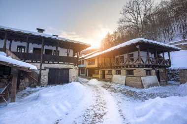 Bulgaristan 'ın Gabrovo kenti yakınlarındaki Mimari Kompleks Etar' daki (Etara) eski geleneksel Bulgar evi. Kışın gün batımında kar yağarken açık hava müzesi. Tarih turizmi