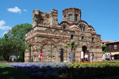 NESSEBAR, Burgaz, BULGARIA - 28 Ağustos 2019: Eski kasabadaki İsa Pantokrator Kilisesi 'nin önündeki çiçek bahçesi. Antik Nesebar Kenti UNESCO 'nun Dünya Mirası