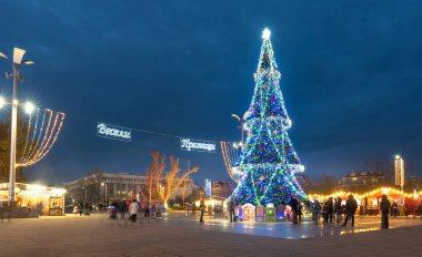 Burgaz, Bulgaristan - 08 Aralık 2019. Burgaz şehrinde gece yılbaşı ışıkları süslemesi. Kasabanın Troikata meydanındaki güzel ışıklandırılmış kostüm ağacı. Alexandrovska Caddesi