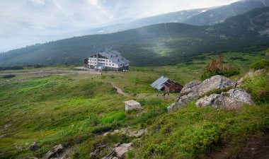Rila, Bulgaria. Mountain hut in Rila mountain. One of the most visited nature places of tourists and top landmark. Sightseeing with green and blue colors. Panorama view clipart