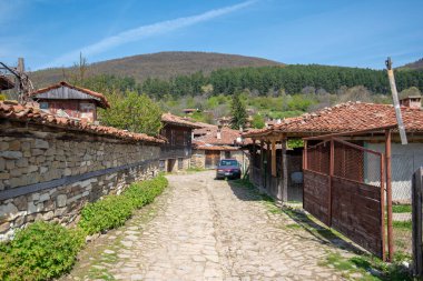 Zheravna, Kotel, Bulgaristan - 14 Mayıs 2019: Kırsal evlerin mimari rezervi ve Bulgar ulusal diriliş döneminden kalma dar kaldırımlı sokaklar. Geleneksel evler