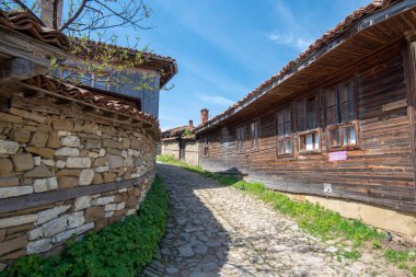 Zheravna, Kotel, Bulgaristan - 14 Mayıs 2019: Kırsal evlerin mimari rezervi ve Bulgar ulusal diriliş döneminden kalma dar kaldırımlı sokaklar. Geleneksel evler