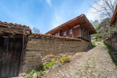 Zheravna, Kotel, Bulgaristan - 14 Mayıs 2019: Kırsal evlerin mimari rezervi ve Bulgar ulusal diriliş döneminden kalma dar kaldırımlı sokaklar. Geleneksel evler