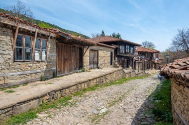 Zheravna, Kotel, Bulgaristan - 14 Mayıs 2019: Kırsal evlerin mimari rezervi ve Bulgar ulusal diriliş döneminden kalma dar kaldırımlı sokaklar. Geleneksel evler
