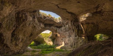 Devetaki köyü yakınlarındaki Devetashka Mağarası 'na ve Bulgaristan' ın Lovech kentindeki Osam nehrine bakın. Doğal mucize. Doğu Avrupa 'nın en büyük karst mağaralarından biri, şu anda 30.000 yarasaya ev sahipliği yapıyor.