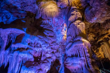 Venetsa Cave near Vidin, Bulgaria. Beautiful colorful and illuminated cave full with semiprecious onyx stones. Flowstones, stalactites and stalagmites lighted in different vivid colours. clipart