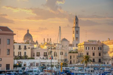 Bari, Puglia, İtalya - 23 Şubat 2019: Bari şehri San Nicola Bazilikası ve Romanesque Katedrali ile gün batımında. Bari, İtalya. Marina 'dan deniz manzaralı. Apulia bölgesi