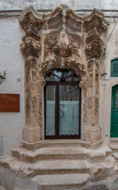 İtalya 'nın Puglia şehrinde bir barok evinin ön cephesi, Apulia. Eski ahşap mermer kapının bir parçası 