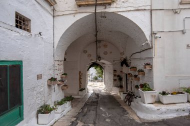Ostuni, Puglia, İtalya - 15.02.2020: Eski kentin sokak manzarası - Brindisi ili, Apulia bölgesi. Eski tarihi merkezde geleneksel beyaz yıkamalı evler resim kadar dar.