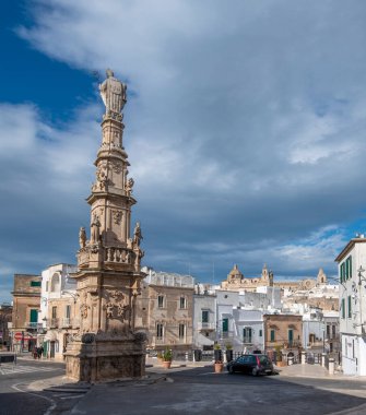 Ostuni, Puglia, İtalya - Obelisco Sant 'Oronzo obelisk (Colonna di Sant' Oronzo) Ostuni 'nin (Piazza della Liberta Meydanı) ana meydanında. Gün batımında Apulia 'da beyaz bir şehir. 15 Şubat 2020