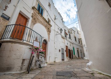 Ostuni, Puglia, İtalya - 15.02.2020: Eski kentin sokak manzarası - Brindisi ili, Apulia bölgesi. Eski tarihi merkezde geleneksel beyaz yıkamalı evler resim kadar dar.