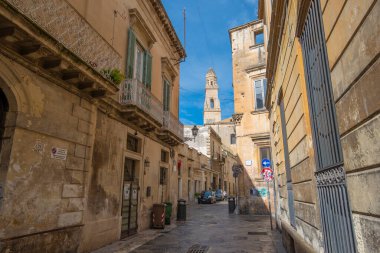 Lecce, Puglia, İtalya - 08 Mart 2019: Ortaçağ sokağı ve eski şehrin tarihi merkezi. Antik bir kapı ya da kapı, heykeller ve evlerin dış görünüşü. Apulia Bölgesi