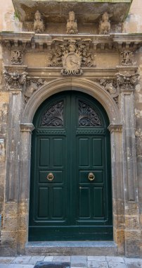 Lecce, Puglia, İtalya - 08 Mart 2019: Eski şehrin ortaçağ tarihi merkezi. Eski bir kapı ya da kapının görüntüsü ve ayrıntıları. Apulia Bölgesi