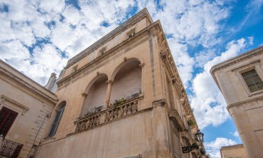 Lecce, Puglia, İtalya - 08 Mart 2019: Ortaçağ sokağı ve eski şehrin tarihi merkezi. Antik bir kapı ya da kapı, heykeller ve evlerin dış görünüşü. Apulia Bölgesi