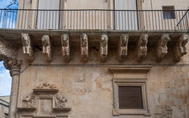 Lecce, Puglia, İtalya - 08 Mart 2019: Ortaçağ sokağı ve eski şehrin tarihi merkezi. Antik bir kapı ya da kapı, heykeller ve evlerin dış görünüşü. Apulia Bölgesi