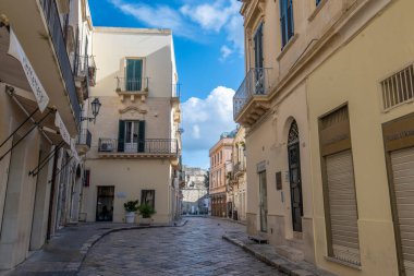 Lecce, Puglia, İtalya - 08 Mart 2019: Ortaçağ sokağı ve eski şehrin tarihi merkezi. Antik bir kapı ya da kapı, heykeller ve evlerin dış görünüşü. Apulia Bölgesi