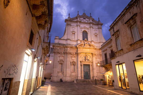 LECCE, Puglia, Italy. Фасад старинного барокко церкви Санта-Ирен в историческом центре в старом городе ночью. Регион Апулия.