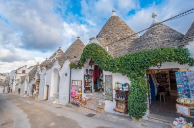ALBEROBELLO, PUGLIA, ITALY - 14 Mart 2019: Itria Vadisi, Apulia, Güney İtalya 'nın karakteristik koni çatılı beyaz evleri Alberobello' nun ünlü Trulli manzarası. 