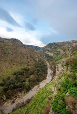 Tarih öncesi sassi mağaraları, mağaralar ve evler İtalya 'nın Matera kentindeki Basilicata vadisinin karşısındaki yamaçta görülebiliyor. Bölgedeki Gravina nehri kanyonu.