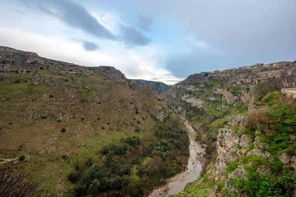 Tarih öncesi sassi mağaraları, mağaralar ve evler İtalya 'nın Matera kentindeki Basilicata vadisinin karşısındaki yamaçta görülebiliyor. Bölgedeki Gravina nehri kanyonu.