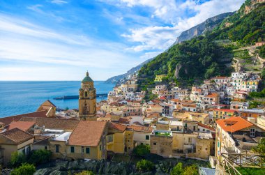 Mavi deniz ve bulutlu gökyüzü ile Amalfi 'nin ve katedralin manzarası. İtalya 'nın Positano kenti yakınlarındaki renkli evler ve Akdeniz manzarası çok güzel..