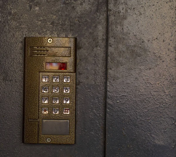 intercom on the door of the house with a code to enter with buttons numbers brown