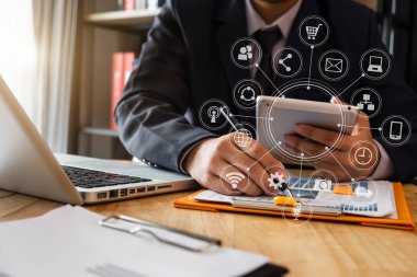 Dizüstü bilgisayar ile modern ofis ve dijital tablet bilgisayar Vr simgesi diyagramı Bürosu'nda sabah ışık ile cep telefonu kullanan kadın elinde