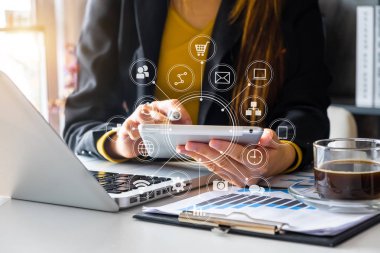 iş kadını ya da dizüstü bilgisayar ve dijital tablet bilgisayar ve sanal arabirimi grafik simgeleri ağ diyagramı ile modern ofis masasında belgede akıllı telefon kullanarak Tasarımcısı