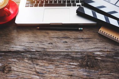Film clapper laptop, tablet, akıllı telefon ve kahve Kupası kalem not etmek üstünde ateş siyah masa üstü görünümü ile başı işleri.
