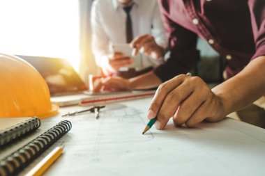 Çalışma ve tablet hakkında konuşan iki meslektaş, ofisteki inşaat sahasında mimari projeyle ilgili bilgisayarı açtılar.