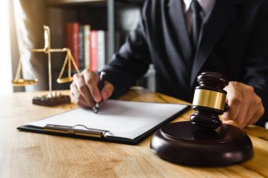 Adalet ve hukuk kavramı. Erkek bir mahkemede yargıç tokmak, dijital tablet bilgisayarınızla sabah hafif ahşap masa üzerinde çalışma 