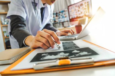 Tıbbi teknoloji kavramı. Akıllı telefon ve stetoskop ve dijital tablet bilgisayar Hastanesi sabah ışığında modern Office ile çalışan doktor