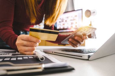 İş kadını elleri akıllı telefon kullanıyor ve dijital katman efektli kredi kartını online alışveriş konsepti olarak tutuyor