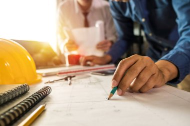 Çalışma ve tablet hakkında konuşan iki meslektaş, ofisteki inşaat sahasında mimari projeyle ilgili bilgisayarı açtılar.