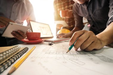 Çalışma ve tablet hakkında konuşan iki meslektaş, ofisteki inşaat sahasında mimari projeyle ilgili bilgisayarı açtılar.