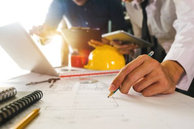 Yaratıcı mimar karanlık çatı ofiste büyük çizimler veya gün ışığına kafede projelendirme