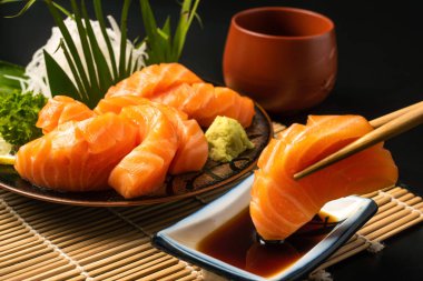 Sashimi, somon, Japon yemek çubukları ve masada wasabi.
