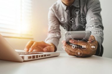 İş kadını el bilgisayarı cep telefonuyla sanal ekranda dijital pazarlama medyasında çalışıyor ve sabah saatlerinde ofiste VR simgesi diyagramı ile modern hesaplama yapıyor. 