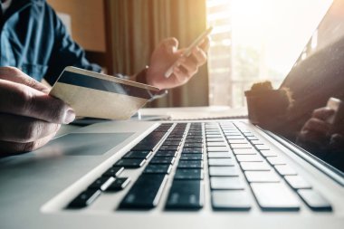 Akıllı telefon kullanan ve dijital katman etkisi diyagramı olan kredi kartı tutan işadamı elleri online alışveriş konsepti olarak kullanılıyor