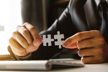 İş çözümleri ve başarı kavramı. Parçalı bulmaca Bürosu'nda sabah ışık bağlayan işadamı el