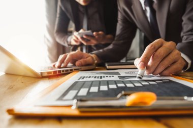 İş ekibi toplantısı. Profesyonel yatırımcı yeni bir başlangıç projesi üzerinde çalışıyor. Mali işler. akıllı telefon, dizüstü bilgisayar ve dijital tablet bilgisayarla sabah ışığı altında