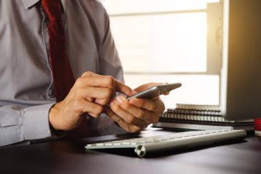 işadamı el akıllı telefon, tablet ödemeler ve holding kredi kartı kullanma online alışveriş, omni kanal, dijital tablet klavye bilgisayar Bürosu'nda güneş ışığı yerleştirme
