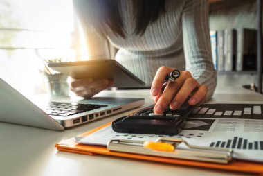 Maliyet, hesap makinesi ve tabletli dizüstü bilgisayarla ilgili finansman ile çalışan işadamı elleri, sabah saatlerinde ofiste akıllı telefon.