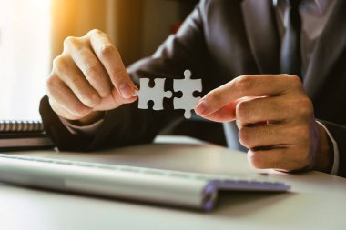 İş çözümleri ve başarı kavramı. Parçalı bulmaca Bürosu'nda sabah ışık bağlayan işadamı el