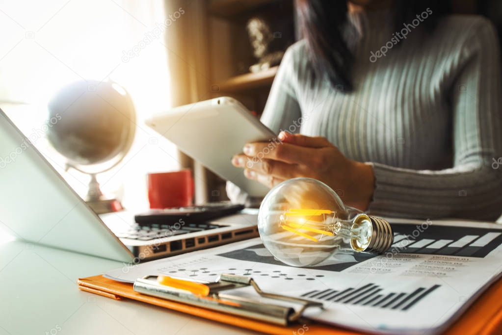 light bulb with business hand working with laptop computer and creative business strategy in morning light